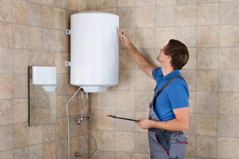 Plombier vérifiant un chauffe-eau électrique mural