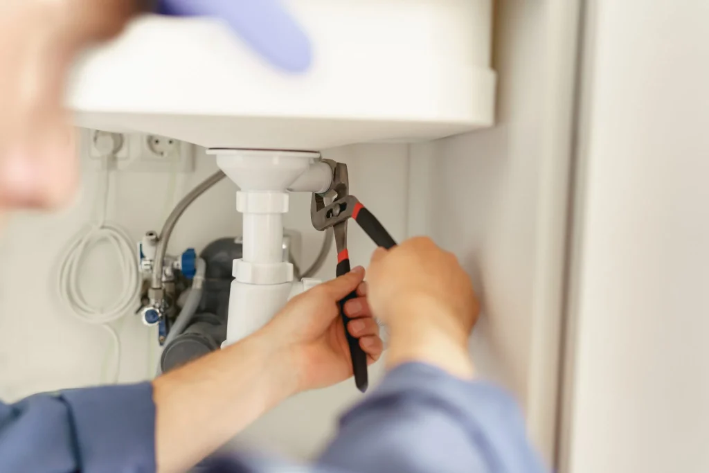 Plombier raccordant un chauffe-eau électrique lors d'un remplacement